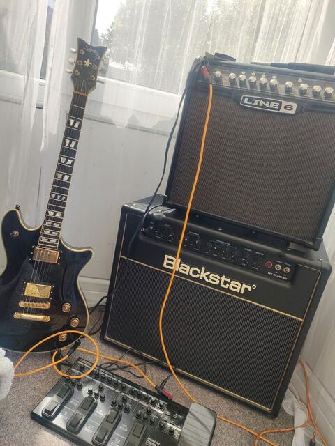 An electric guitar, two amplifiers and a pedalboard